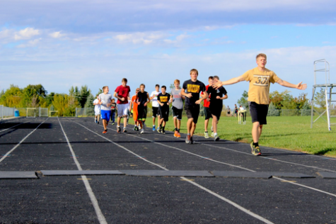 Senior Reid Nichols leads the boys cross country team in a warm up lap at the beginning of practice. The boys finished fifteenth out of 24 teams at the Trojan Invite on Oct. 9, 2014. At the end of the Trojan Invite, the top three runners were injured.
