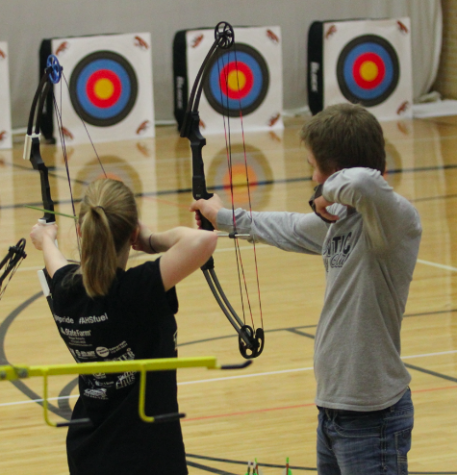 Two archers pull their arrows back as they prepare to shoot.