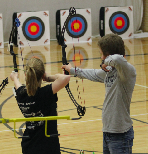 Two archers pull their arrows back as they prepare to shoot.