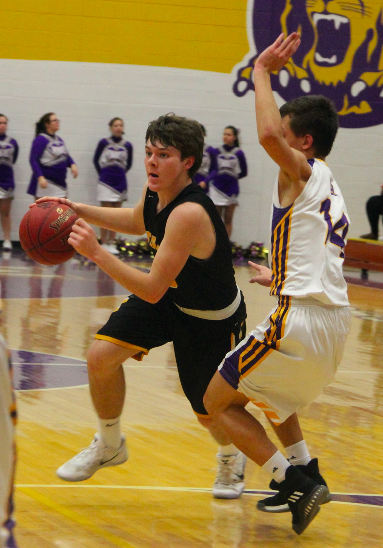 Trojan sophomore Chase Mullenix dribbles aggressively into the lane in a game against Denison-Schleswig
