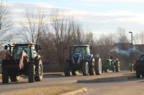 ON OUR WAY - Nate Moen and Nathan Behrends drive their tractors from Wal-Mart to the AHS parking lot.