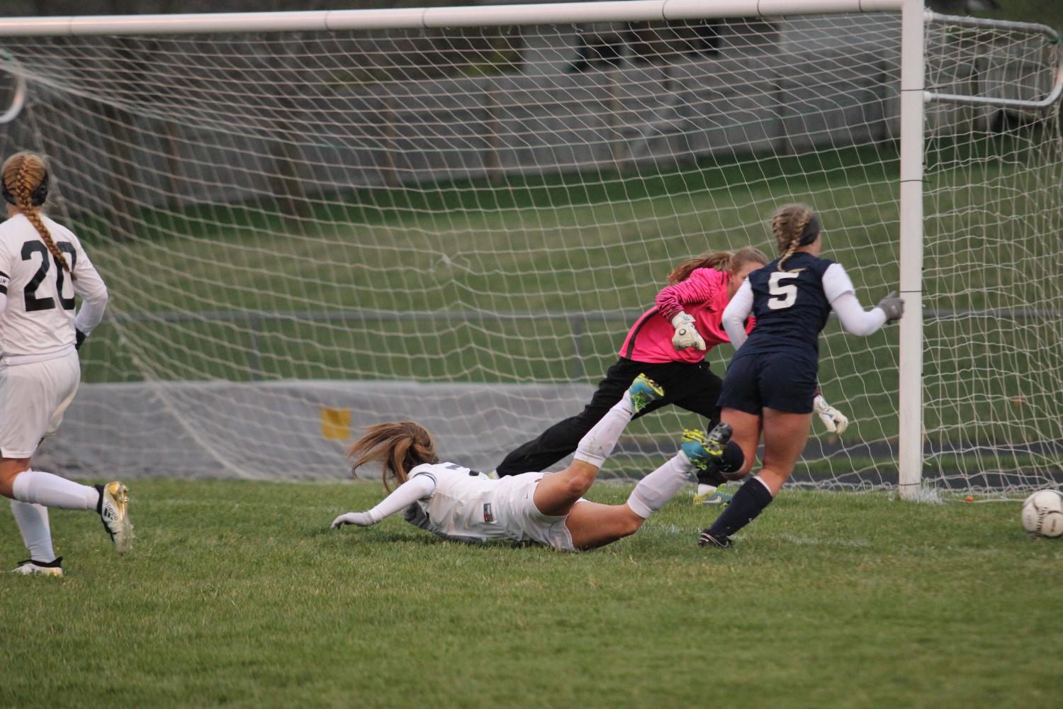 Senior Emily Hohenberger dives to try and block the ball from scoring. 