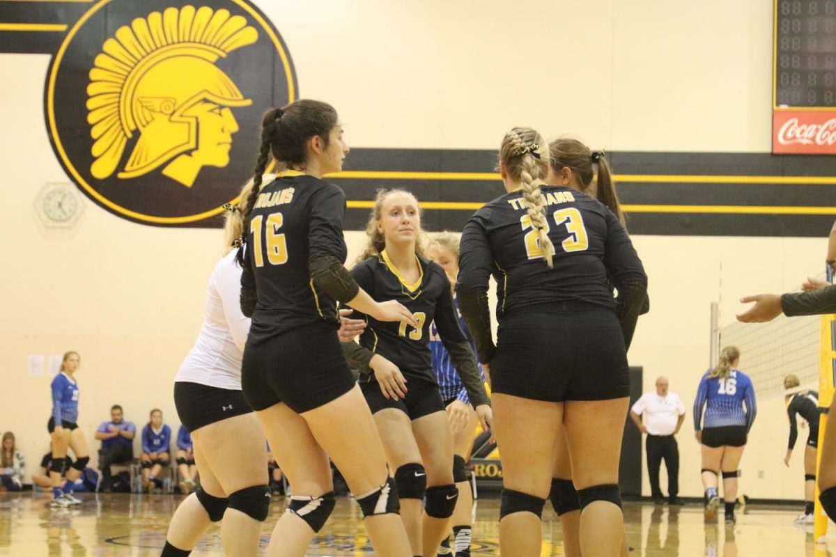 Team comes together after  a point in a game against Earlham. Photo Credit: Hannah Alff 