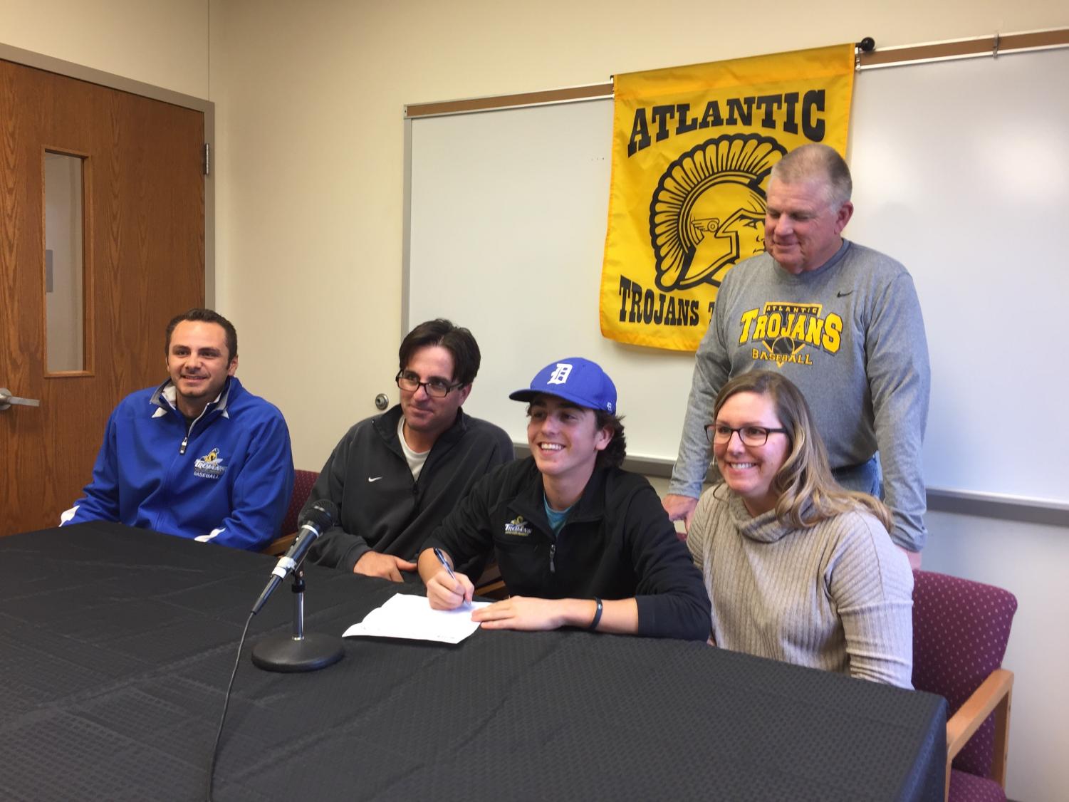 SDSU Coach Brady Banse, Mike McDermott, Cooper McDermott, Christa McDermott, and Gaylord Schelling gather in the conference room to witness Cooper's signing of his letter of intent.