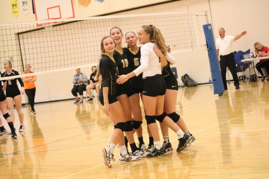 The varsity squad huddles up after an exciting point in a match earlier this season.