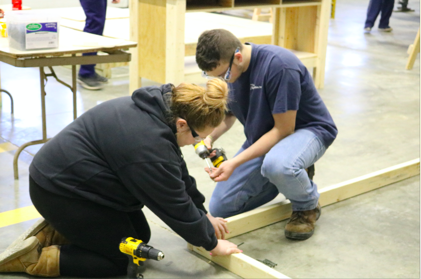 Students Azura Nissen and Trey Clark work on a shed for the Little League Complex.