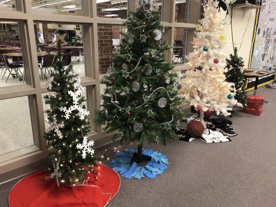 SPREADING CHEER - Christmas trees are being displayed in the media center for the remainder of the semester. Students can vote for their favorite trees during the week of semester tests by dropping money into boxes set in front of each activitys tree.