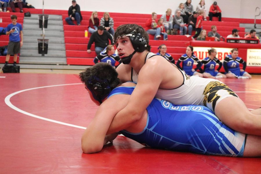 STAY DOWN - Junior Cale Roller takes control over his opponent. Roller was one of three Trojans to secure a John J. Harris individual title, along with senior Chase McLaren and sophomore Joe Weaver.