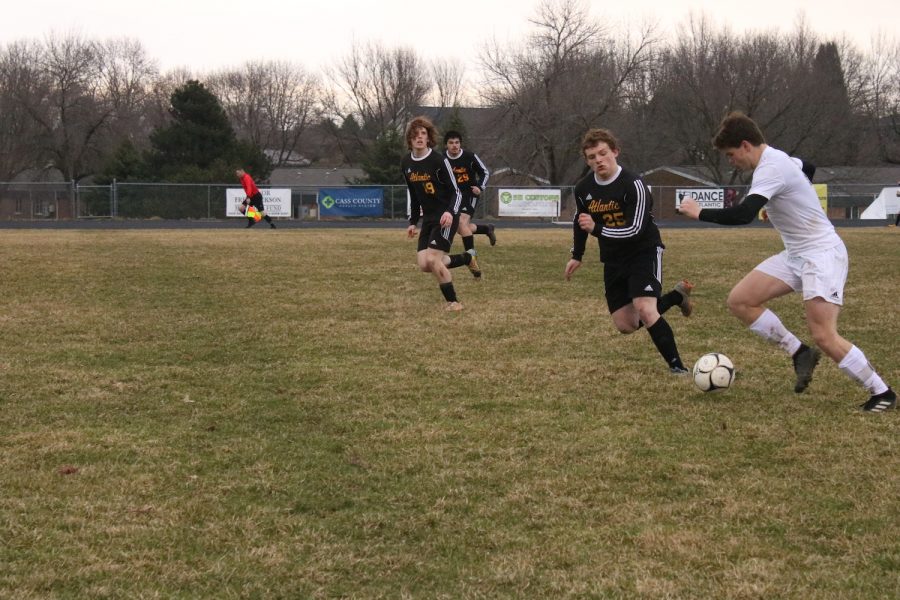 TIME TO STRIKE - Sophomore Devin McKay chases after the ball during the Tri-Center matchup. With goals from Beau Dickerson, Nathan Brockman and Ben Andersen, the Trojans won 3-1.