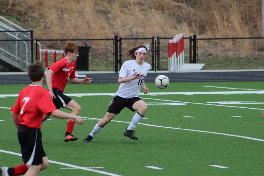 NOT ON MY WATCH - Junior Jackson Mullin races to beat his opponent to the ball. Mullin plays defense for the Trojans and has participated in soccer since his freshman year.