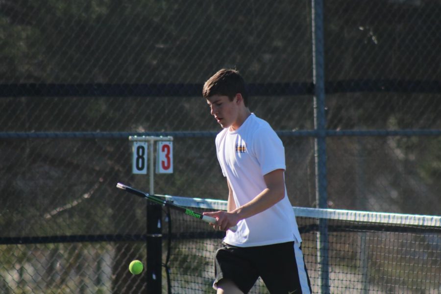 Sophomore Ethan Williams bounces the ball on the changeover. Williams plays the #4 position for the Trojans in duals. 