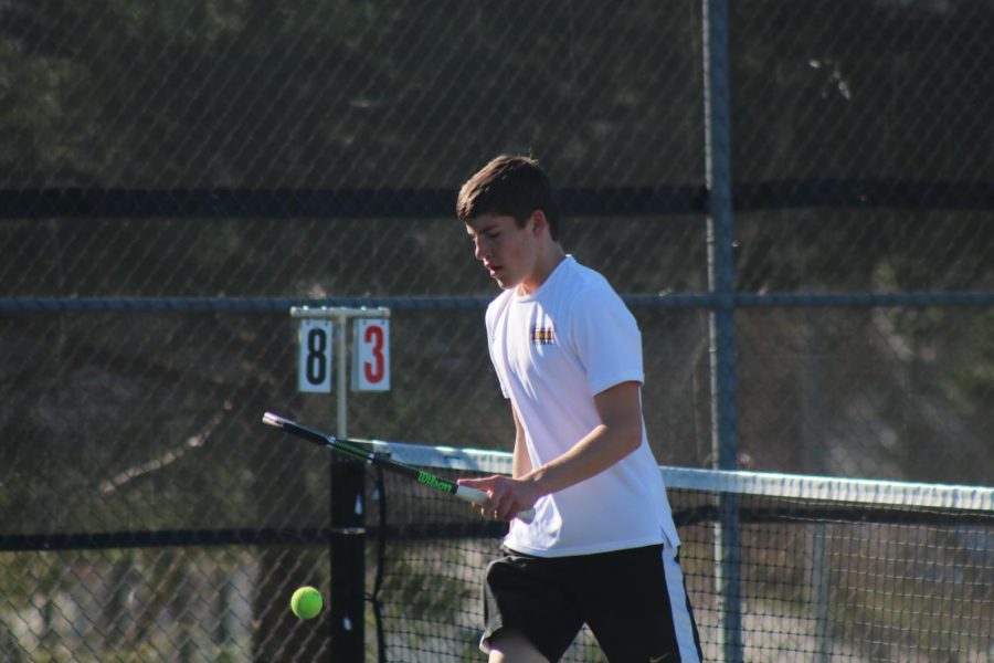 Sophomore+Ethan+Williams+bounces+the+ball+on+the+changeover.+Williams+plays+the+%234+position+for+the+Trojans+in+duals.+