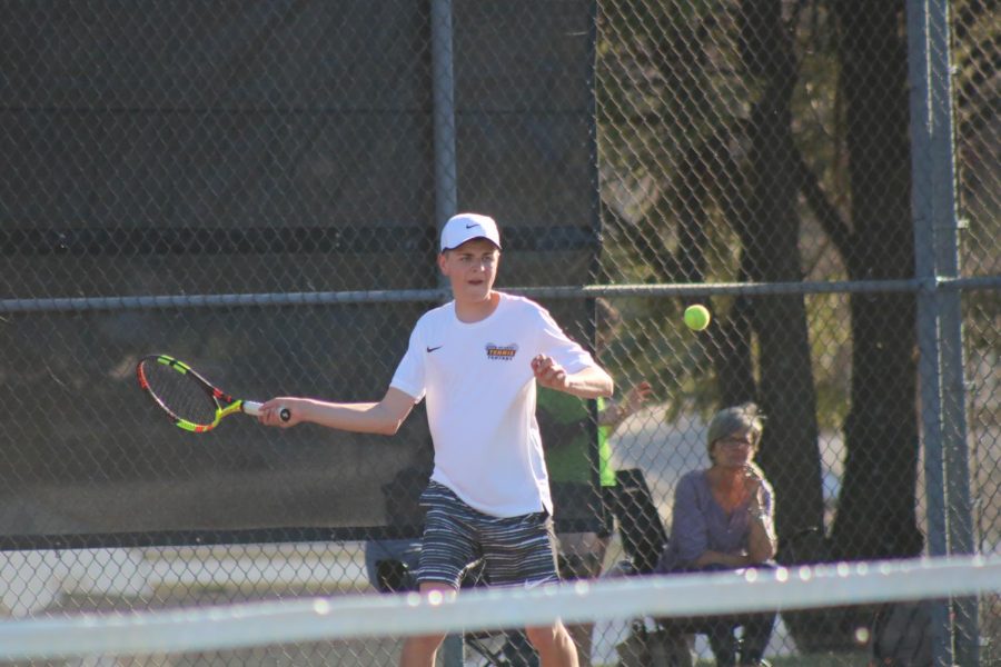 Junior Jesse Reid prepares to hit a forehand to his competitor in the #2 singles match. Reid has played tennis all three years of high school. 