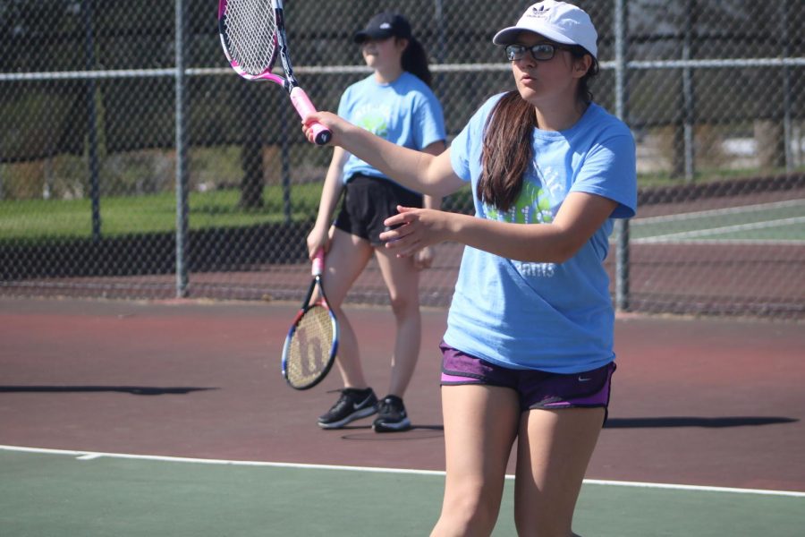 Sophomore Genevieve Martinez eyes her shot in warmups. Martinez won nine matches this season, including a double dip in the history-making win at Harlan. 