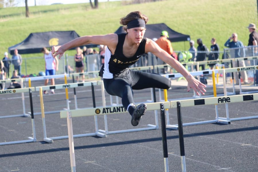 SOARING OVER - Sophomore Joe Weaver leaps over the hurdle during his respective leg of the shuttle hurdle relay. Weaver has participated in track for two years. 