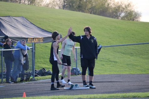 GIMME FIVE - Junior Cale Roller gives sophomore Joe Weaver a good-luck high five before he competes in his race. Roller can often be seen on the throwing field, while Weaver competes in various hurdle events.