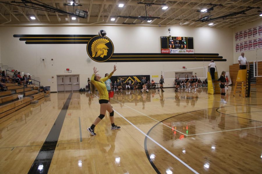 Junior Maycie Waters serves the ball in the AHS gym. Waters plays on both the JV and varsity squads.