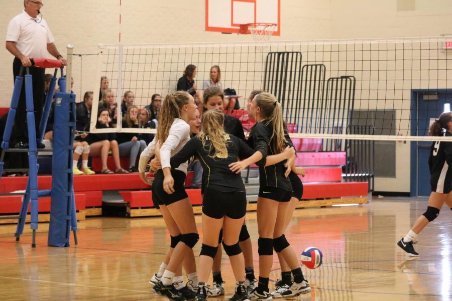 The Trojan volleyball team cheers one another on at a competition last season. The girls came in second in the ACGC quad on Tuesday. 