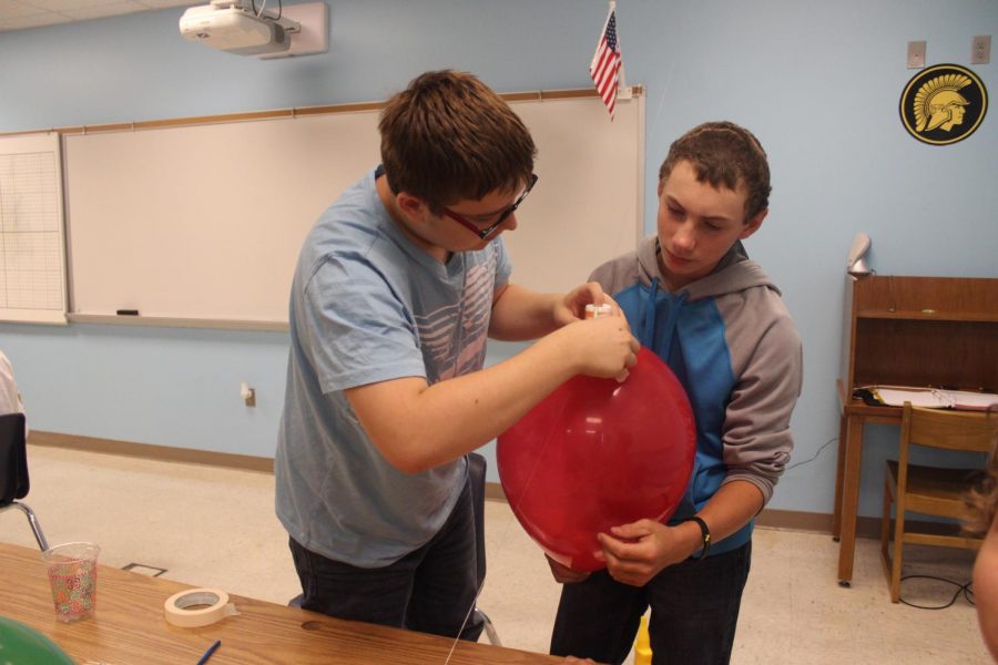 Sophomore Colin Burg and freshman Chase Vogl work on their balloon rocket. This project is just one of many that students will have to complete over the course of the year. 
