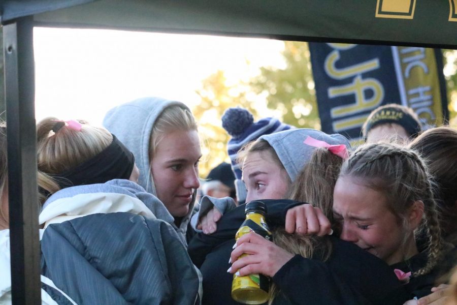 The girls cross country team comforts one another after earning fourth place at districts. Atlantic was 17 points behind the third place team, ADM.