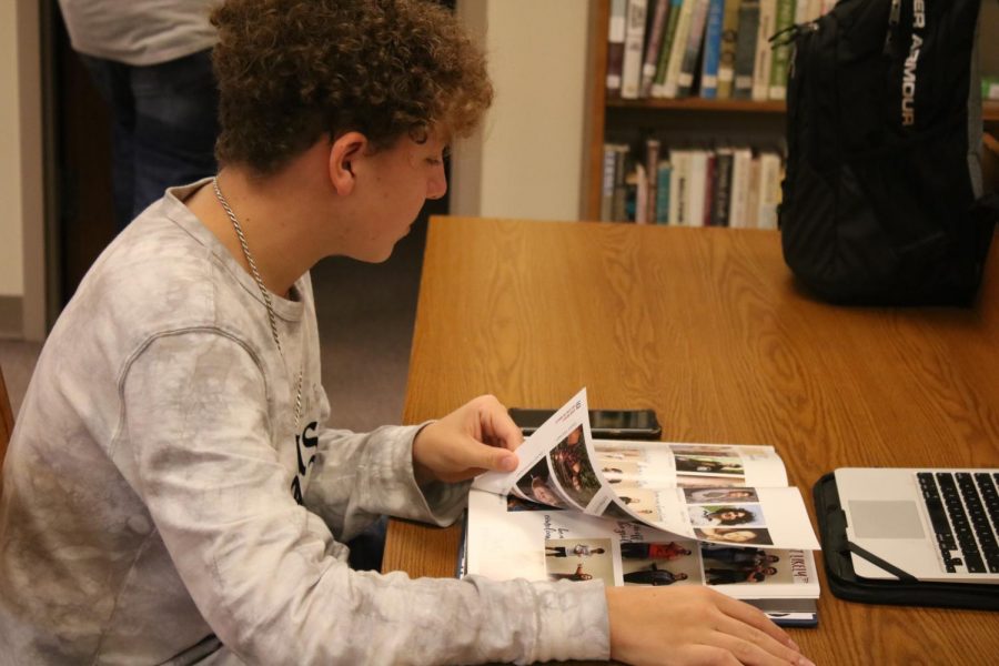Junior Jarrit Smith scopes out the 2018-19 Javelin. The Yearbook Distribution event was held in the ICN room.