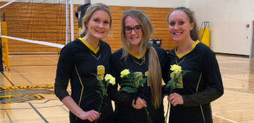 Chloe Davis, Emma Templeton, and Kenzie Waters pose with their roses on Senior Night. The three girls were involved in volleyball all four years of high school.