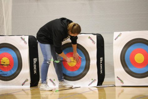 Freshman Halle Copeland collects her arrows during the bullseye event. Copeland finished first amongst the Trojan girls in the bullseye competition.