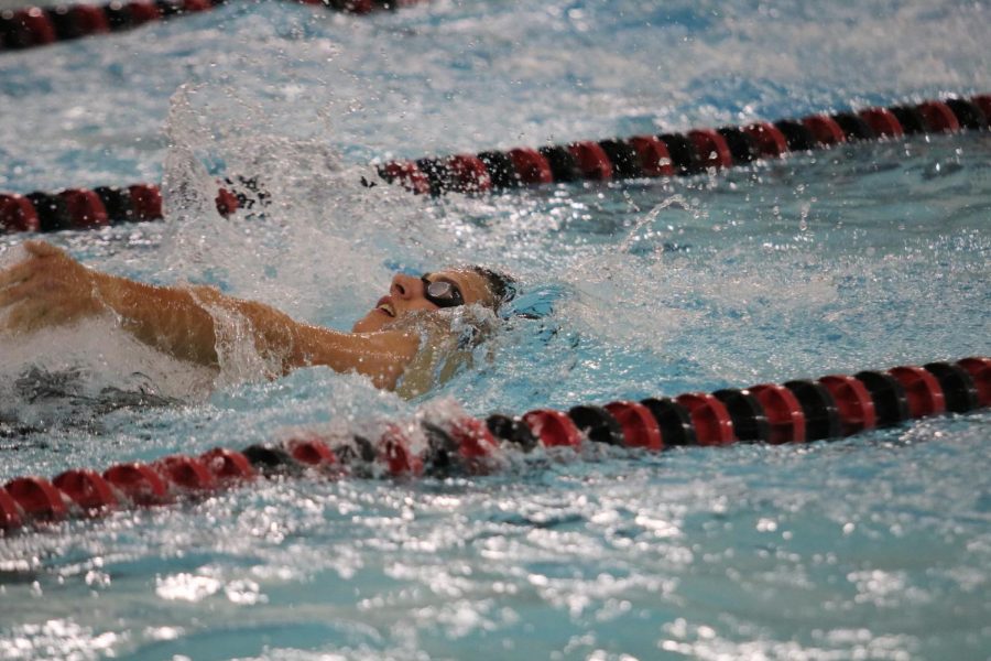 Senior Cole Sampson does the backstroke at a home meet. On Monday, Sampson was a part of the two winning relay teams.