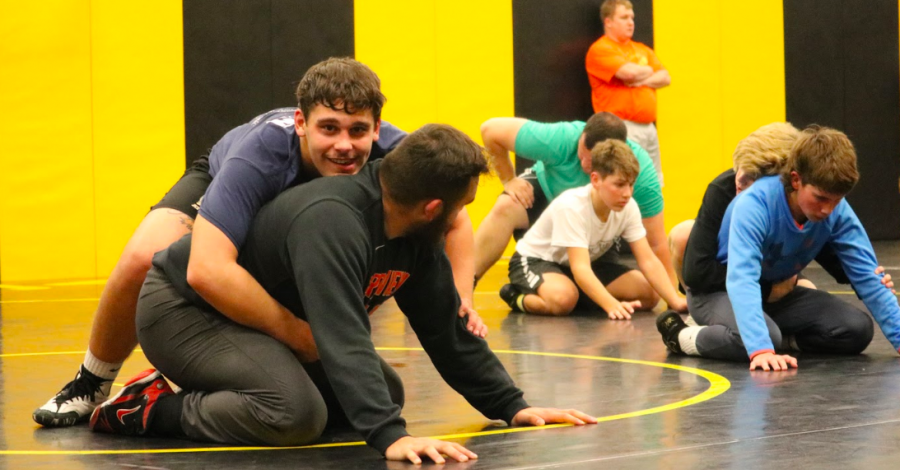 Senior Cale Roller practices his moves on assistant coach Connor Larson during practice. Roller has participated in wrestling throughout high school and has developed many skills.