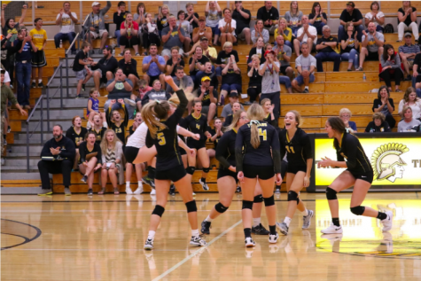 The Trojans celebrate a point together from their game in Harlan last Tuesday. They won their match against Clarinda, 3-2.