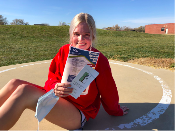 Sophomore Claire Wiederstein holds Student Assistant Program pamphlets provided by the school. Wiederstein encourages those struggling with mental health to "go get help, and find coping strategies."  