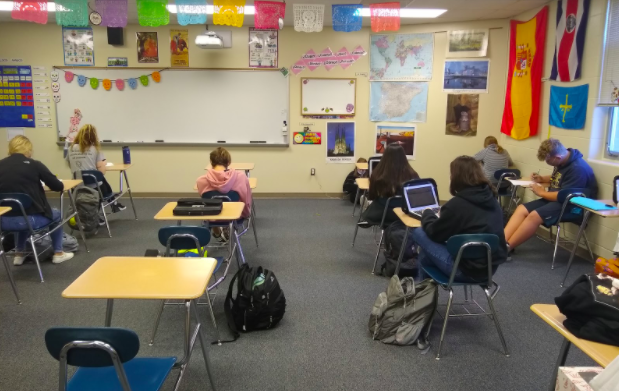 Students finish up a quiz in Trisha Niceswanger’s second-period Spanish 1 class. The desks in Niceswanger’s classroom are standard for most of the school and require students to look down at what they’re doing. This can contribute to neck pain.