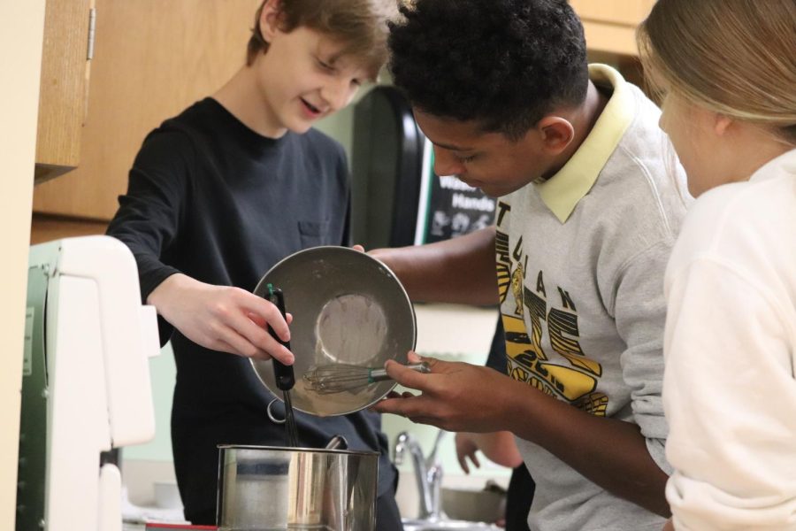 DUMPY - Nick Andersen and Dante Hendrigton  dump their chocolate mix into the pot as Jersey Phippen looks on. Cooking pudding teaches students about thickening methods and use of dairy. The goal was to make a tasty pudding without lumps.