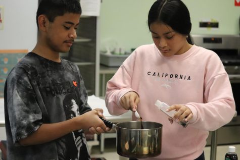 TEAMWORK MAKES THE DREAMWORK - Markes Mark and Nerensia Narios add ingredients to flavor the pudding. Students were assigned to groups of three or four at the beginning of the year. These groups have helped each other with most of the cooking projects.