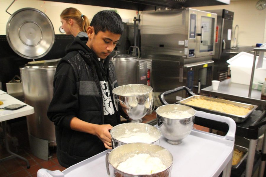 Freshman Markes Mark places all the ingredients together after making four batches of whipped cream. Mark volunteered to help the event to gain community service hours for his class in leadership. He, along with sophomore Mollie Gill and senior Kobe Moss worked behind the scene to make all the meals. 