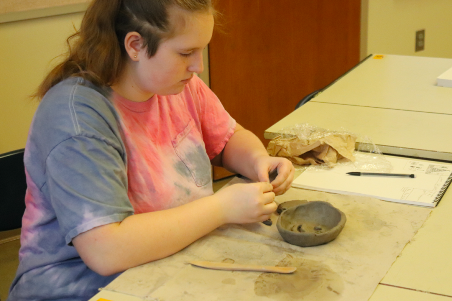 Freshman Zoey Auten works on her clay pinch pot in art class.
