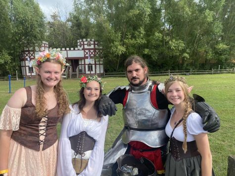 Caption: Katie, Nina, and Eleanor pose with their champion knight, Sir Daniel, after the joust to the death. Jousting was one of the big events at the renaissance festival.