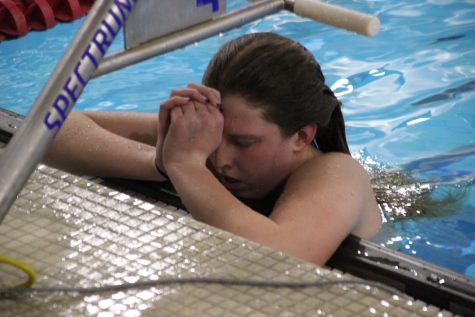 Lexi Reynolds is shown taking deep breaths after a race at a swim meet.