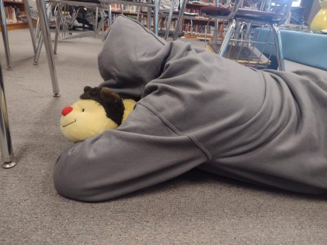 Senior Alex Garcia sleeps on English teacher Allison Berryhills floor. Drinking too much caffeine can cause tiredness.