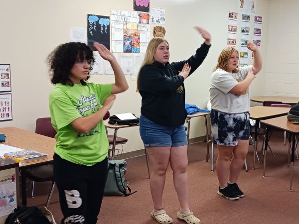 Students J. Molina, Brady Wagner, and Molly Harris learn to dance a traditional Japanese festival dance.