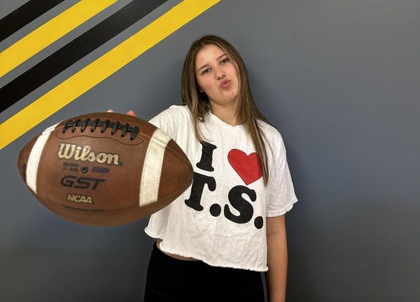 Junior Isabelle Symonds poses with a football while wearing an I heart Taylor Swift shirt. 