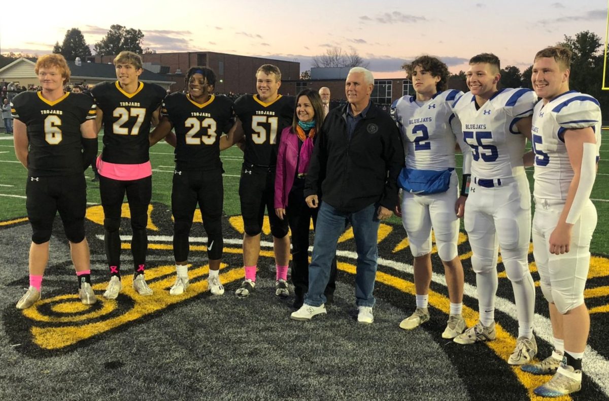 The Atlantic Football Team Captains, Karen and Mike Pence, and the Perry Team Captains stand on the Trojan Head before the coin toss.