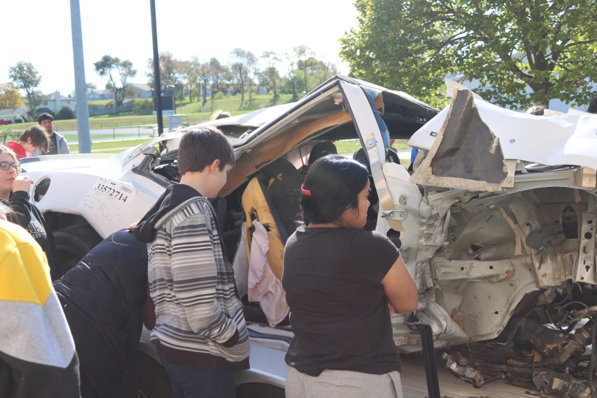 Seniors Kipp Namanny and Katreen Buliche look inside the damaged Camaro. The AHS students watched a video on the crash and heard from the officer that was in charge of reconstructing the vehicle after the crash.