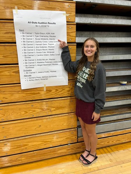 Senior Nicole Middents points to her name on the Clarinet results poster. Middents has made All-State for three years.