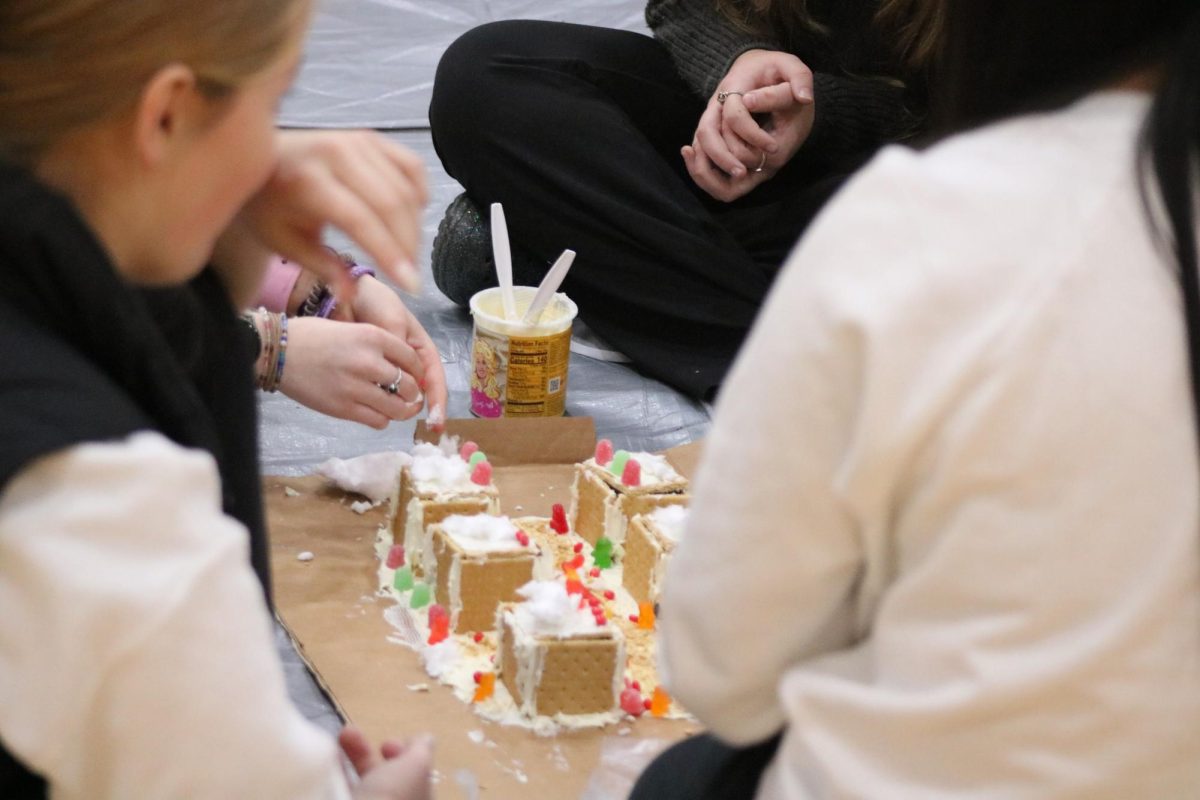 THE MORE THE MERRIER - Olivia Olson and Gabriella Mendez observe intently the progress being made on their gingerbread village. The group was in a fierce competition with the other groups in the school. However they came up short and were unsuccessful in reaching the top 10.