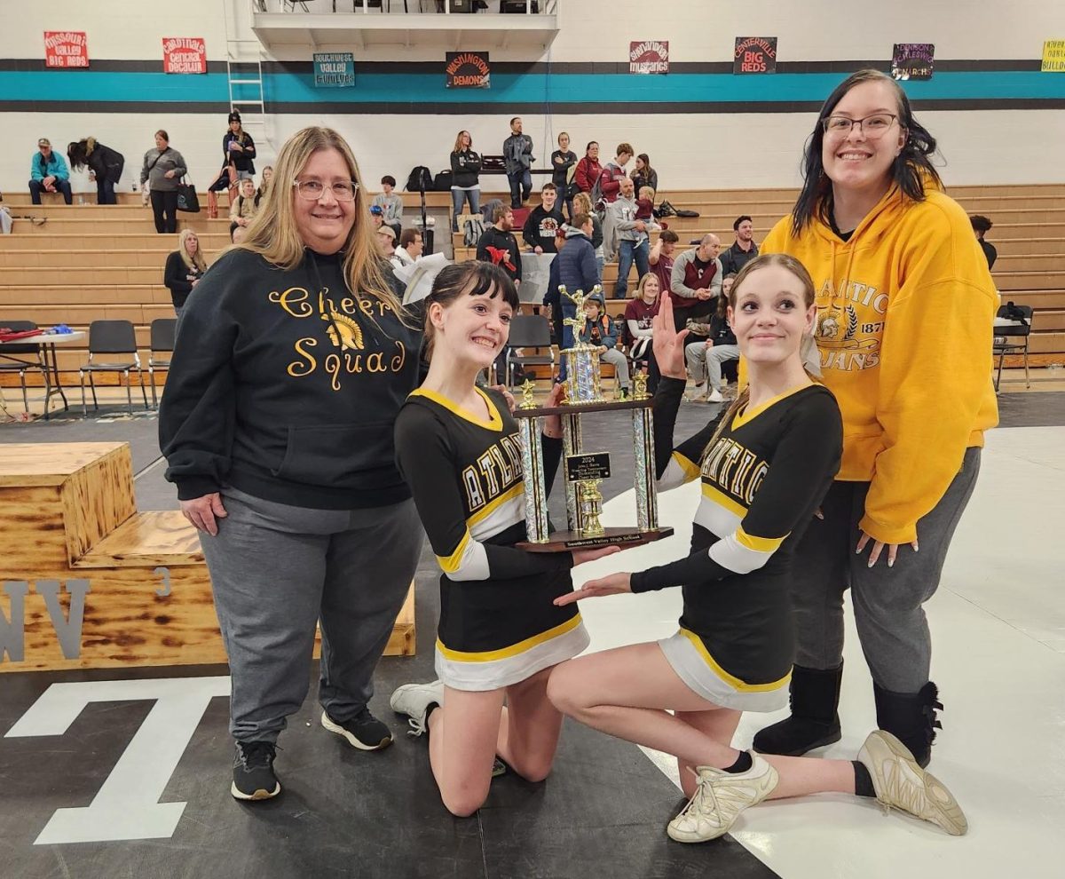 Head Cheer Coach Julie Phippen, Cheerleaders Gabby Porter and Amaurie McCullough, and Assistant Coach Kayla Mendenhall pose with the trophy. They won the spirit award at the John J. Wrestling Tournament.