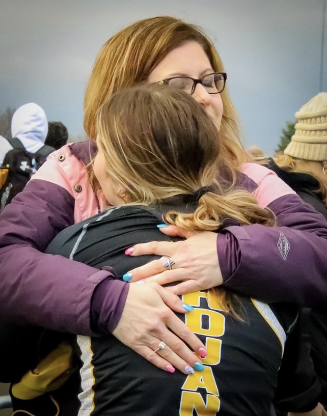 The writer hugs her mother at a track meet, May 5, 2023. It was her mothers birthday.