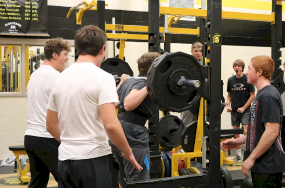 SETTING THE BAR HIGH - Sophomore Matt Pollock is surrounded by his buddies in weights class. Pollock hit a new max while doing test outs. At first he struggled getting the bar up but the class stopped to cheer him on as he successfully squatted 325lbs.
