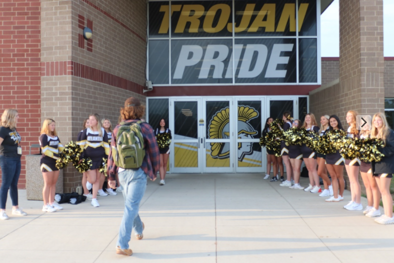 Sophomore Zephyr Mitchell walks into the AHS entryway lined by cheerleaders. Every Friday on the day of a home football game, the cheerleaders would greet those who walked into class.