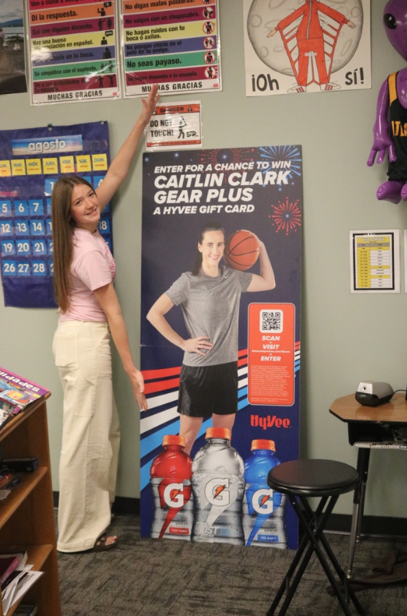 Junior Aubrey Winford stands beside a promotional posterboard.